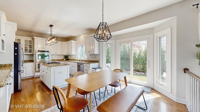 1531 Walnut St, Western Springs, IL 60558 - kitchen featuring appliances with stainless steel finishes, a sink, white cabinetry, wood finished floors, and a chandelier