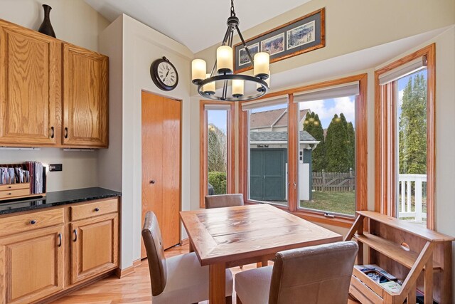 1496 Trailwood Dr, Crystal Lake, IL 60014 - dining space with a chandelier, vaulted ceiling, and light wood-style flooring