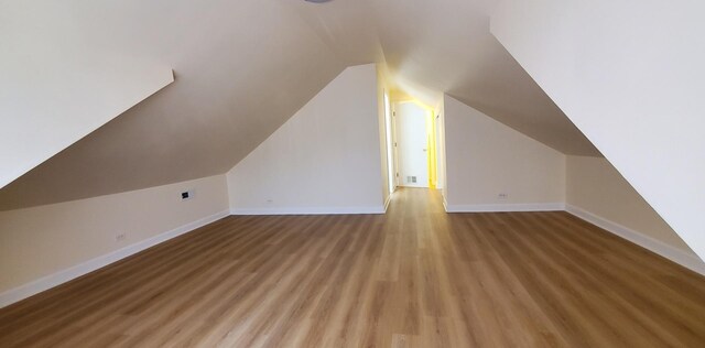 4627 W Schubert Ave, Chicago, IL 60639 - bonus room featuring baseboards, lofted ceiling, and light wood-style floors