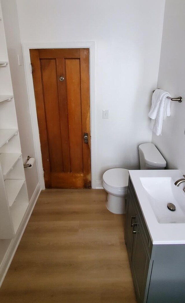 4627 W Schubert Ave, Chicago, IL 60639 - bathroom featuring toilet, wood finished floors, baseboards, and vanity
