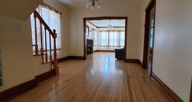 4627 W Schubert Ave, Chicago, IL 60639 - interior space with a chandelier, baseboards, stairs, a stone fireplace, and light wood-style floors