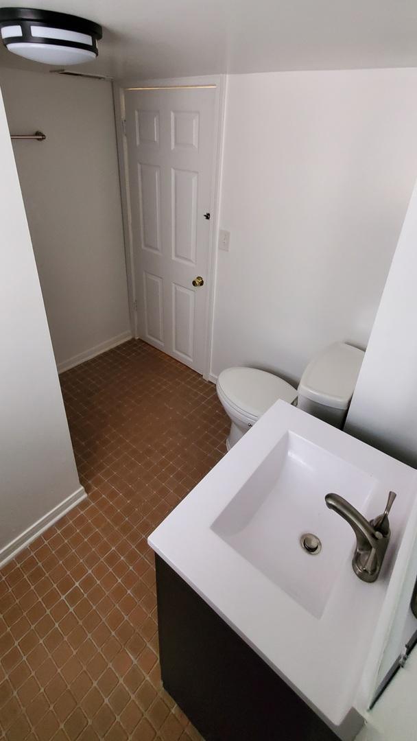 4627 W Schubert Ave, Chicago, IL 60639 - bathroom with toilet, vanity, tile patterned floors, and baseboards