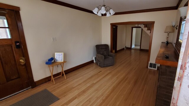 4627 W Schubert Ave, Chicago, IL 60639 - interior space with visible vents, crown molding, light wood-style floors, and an inviting chandelier