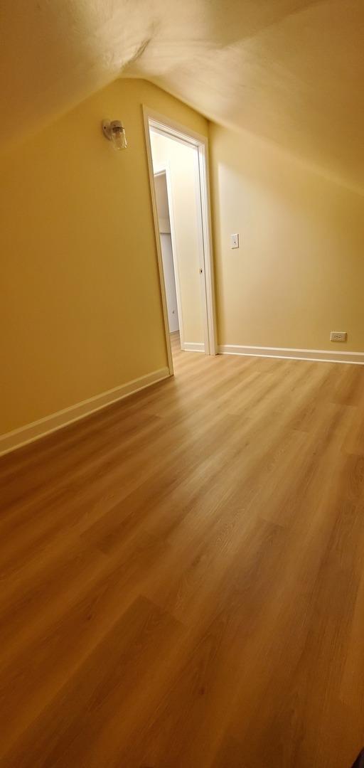4627 W Schubert Ave, Chicago, IL 60639 - bonus room featuring baseboards, vaulted ceiling, and light wood finished floors