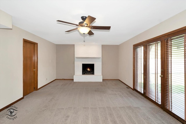 unfurnished living room with baseboards, light carpet, a fireplace, and ceiling fan