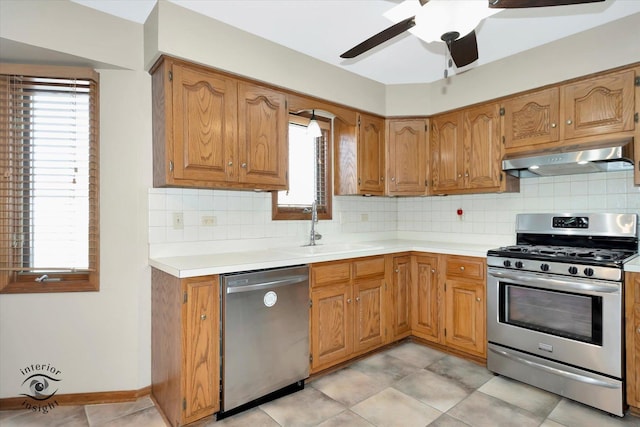 kitchen featuring a sink, under cabinet range hood, ceiling fan, light countertops, and appliances with stainless steel finishes