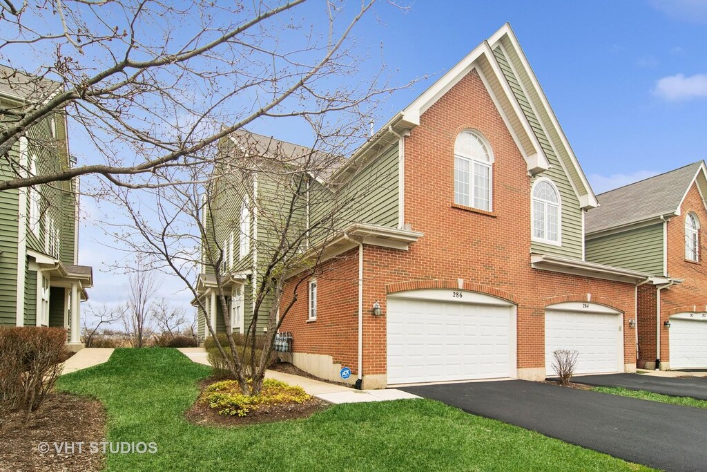 286 W Fairview Cir, Palatine, IL 60067 - view of front of property featuring brick siding, driveway, a garage, and a front lawn