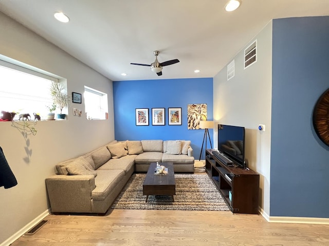 living area with ceiling fan, visible vents, and wood finished floors