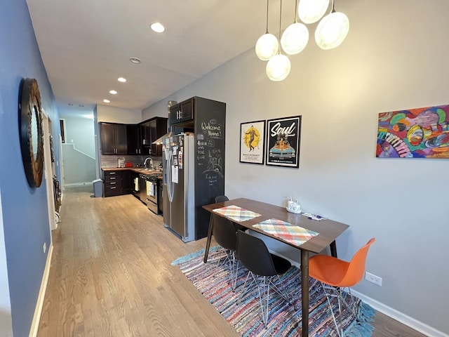 dining space with baseboards, recessed lighting, and light wood-type flooring