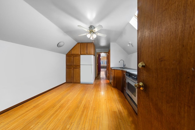 bonus room with a sink, light wood-style floors, ceiling fan, vaulted ceiling, and baseboards