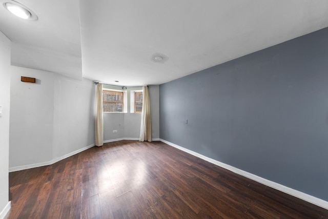empty room featuring wood finished floors and baseboards