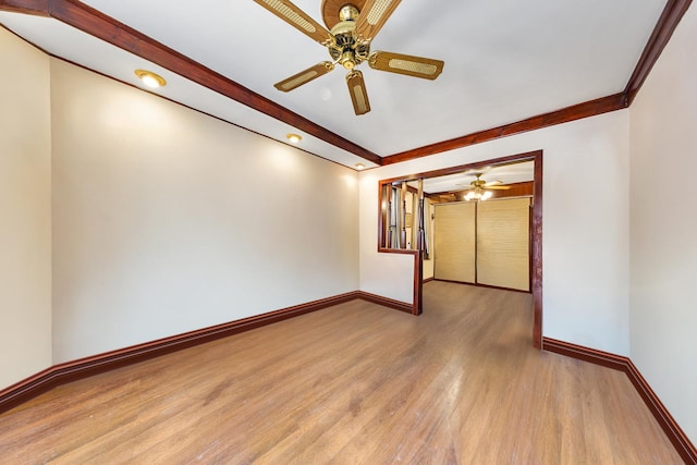 spare room featuring wood finished floors, ceiling fan, beamed ceiling, and baseboards