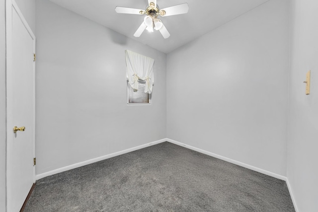 spare room featuring baseboards, dark colored carpet, and a ceiling fan