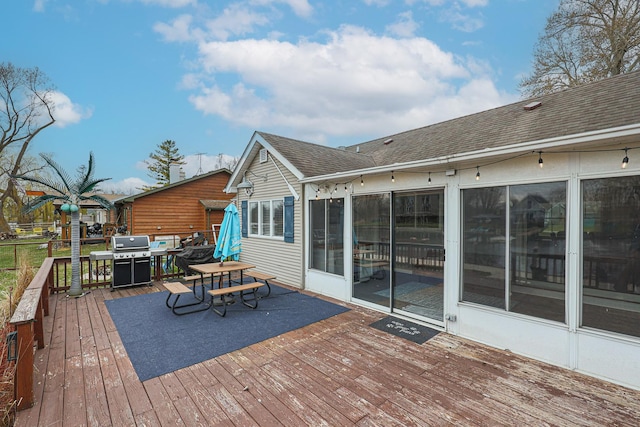 wooden deck with outdoor dining area and area for grilling