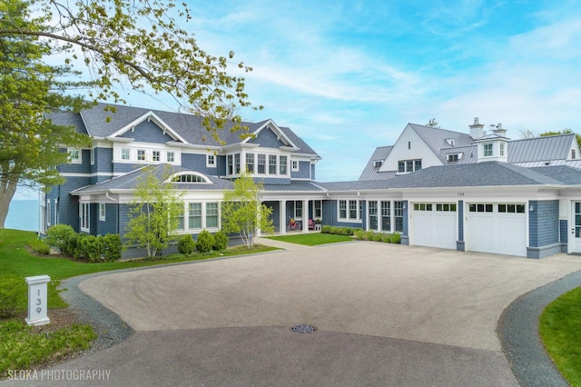 shingle-style home with driveway and an attached garage
