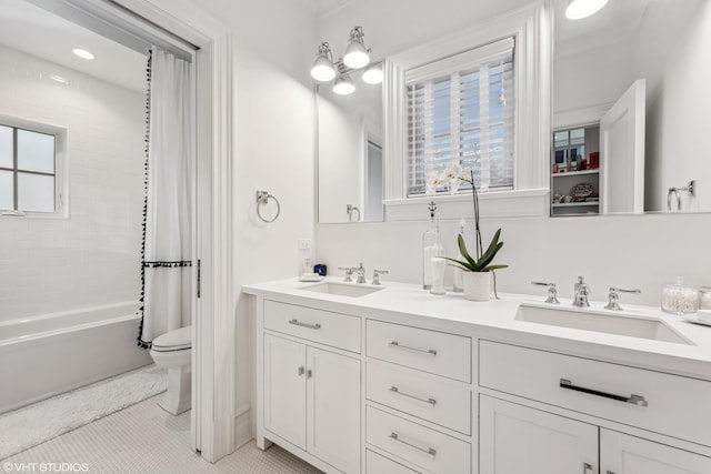 bathroom featuring toilet, double vanity, shower / bath combo with shower curtain, and tile patterned flooring