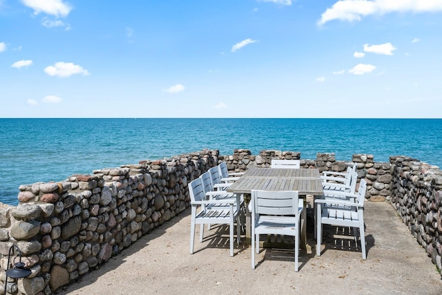 view of patio with a water view and outdoor dining area