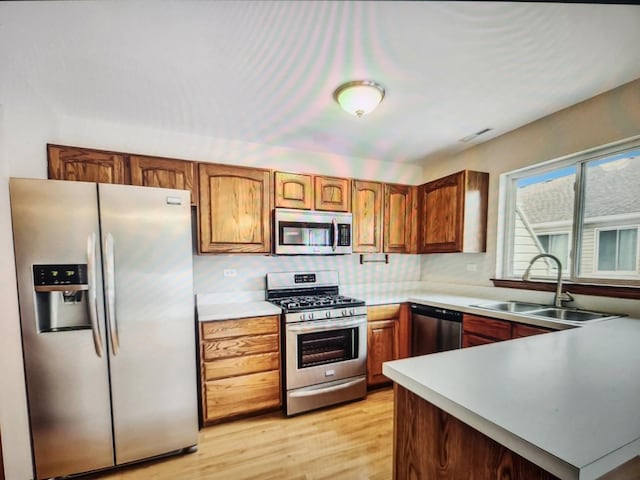 1208 Fox Hill Ln, North Aurora, IL 60542 - kitchen featuring light wood-style flooring, appliances with stainless steel finishes, a sink, light countertops, and decorative backsplash