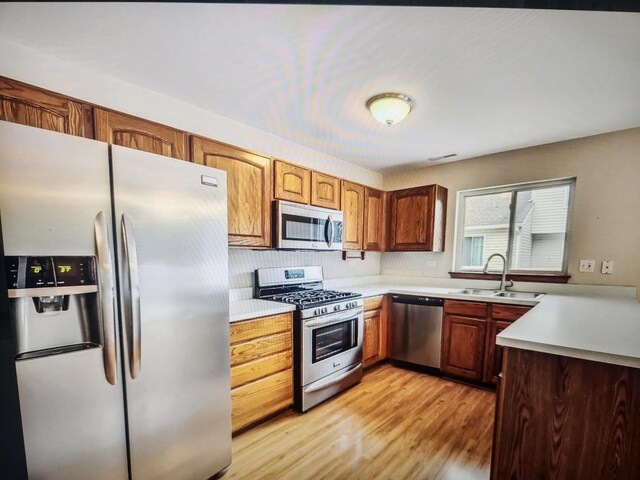 1208 Fox Hill Ln, North Aurora, IL 60542 - kitchen featuring light wood-style flooring, a sink, light countertops, stainless steel appliances, and decorative backsplash