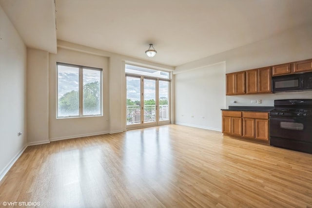 3630 N Harlem Ave Unit 410, Chicago, IL 60634 - kitchen featuring black appliances, brown cabinetry, plenty of natural light, and light wood finished floors