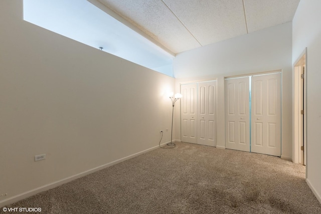 3630 N Harlem Ave Unit 410, Chicago, IL 60634 - unfurnished bedroom with multiple closets, carpet flooring, baseboards, a textured ceiling, and high vaulted ceiling