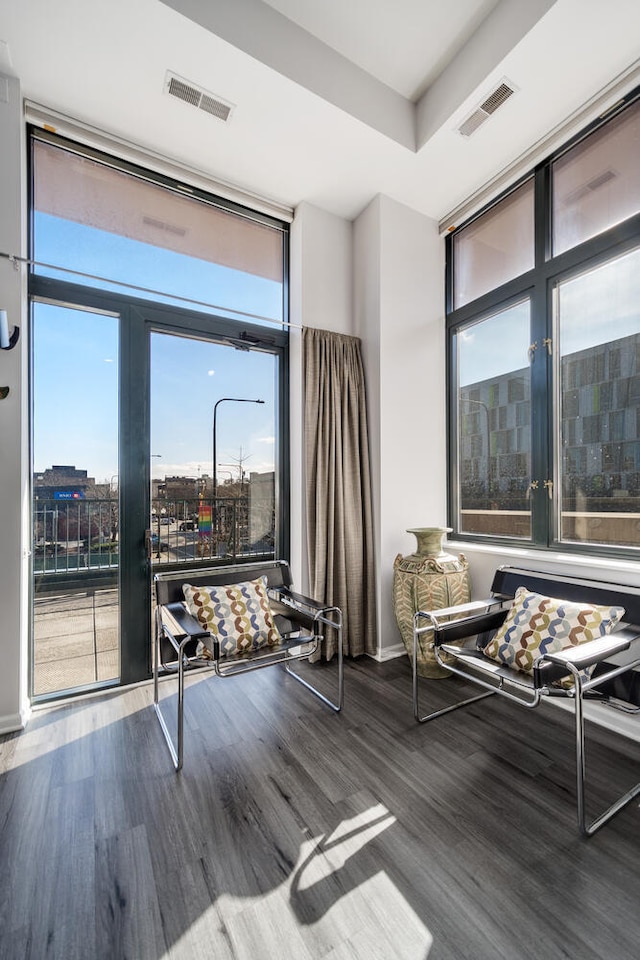 sitting room featuring visible vents, wood finished floors, and a healthy amount of sunlight