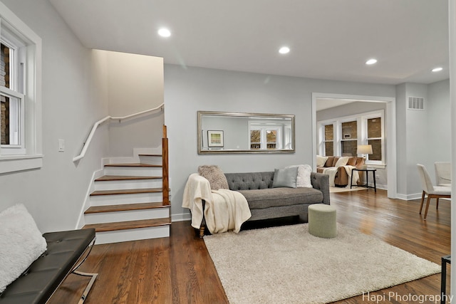 living area with dark wood finished floors, stairs, visible vents, and recessed lighting