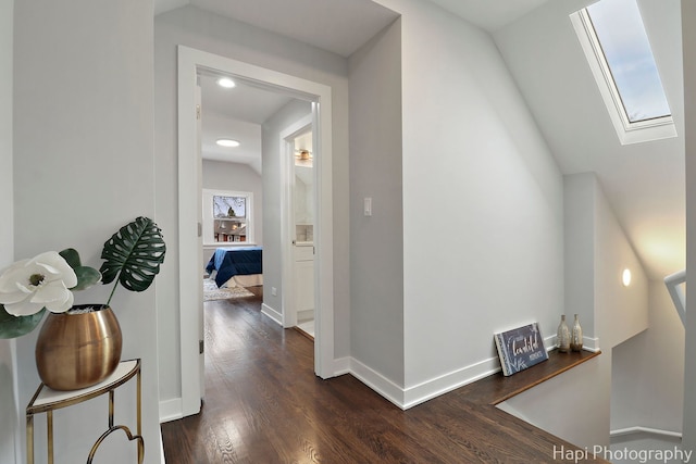 hallway with recessed lighting, baseboards, dark wood-style floors, and a skylight