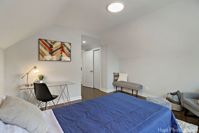 bedroom with baseboards, vaulted ceiling, and wood finished floors