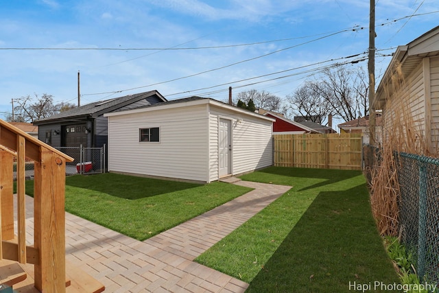 view of yard featuring an outdoor structure, a patio, and a fenced backyard