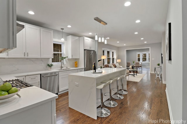 kitchen with stainless steel appliances, a center island, recessed lighting, and a kitchen bar