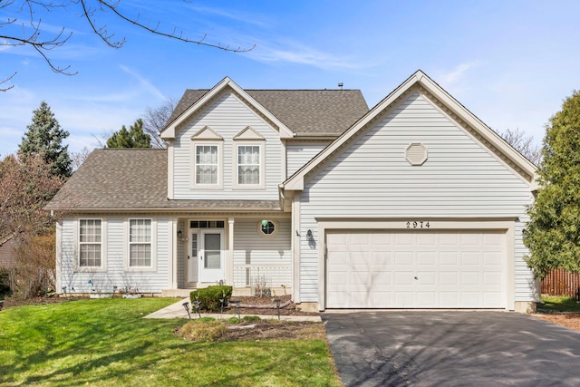 traditional-style house with roof with shingles, driveway, a front yard, and covered porch