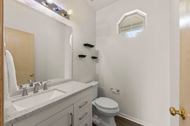 bathroom with vanity, toilet, and wood finished floors