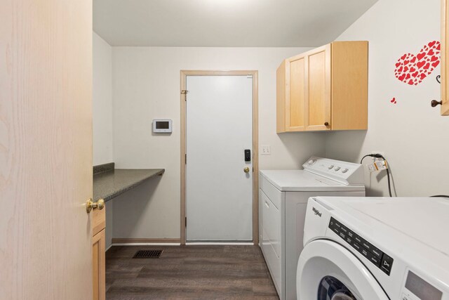 laundry room featuring dark wood-style flooring, visible vents, washing machine and dryer, cabinet space, and baseboards