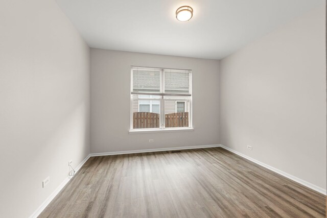 unfurnished room with baseboards and wood finished floors