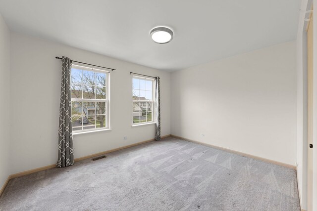 empty room with visible vents, baseboards, and carpet floors