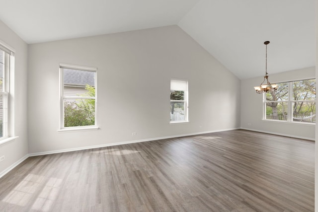 unfurnished room featuring an inviting chandelier, baseboards, and wood finished floors