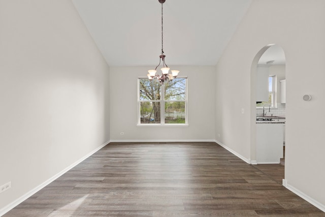 unfurnished dining area featuring a sink, lofted ceiling, a chandelier, and a wealth of natural light