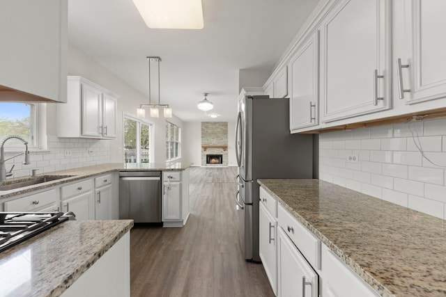 kitchen featuring a sink, decorative backsplash, appliances with stainless steel finishes, and a wealth of natural light