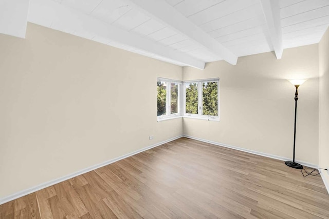 unfurnished room featuring baseboards, light wood-style floors, wooden ceiling, and beam ceiling