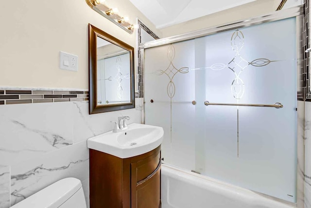 bathroom with tile walls, toilet, and vanity
