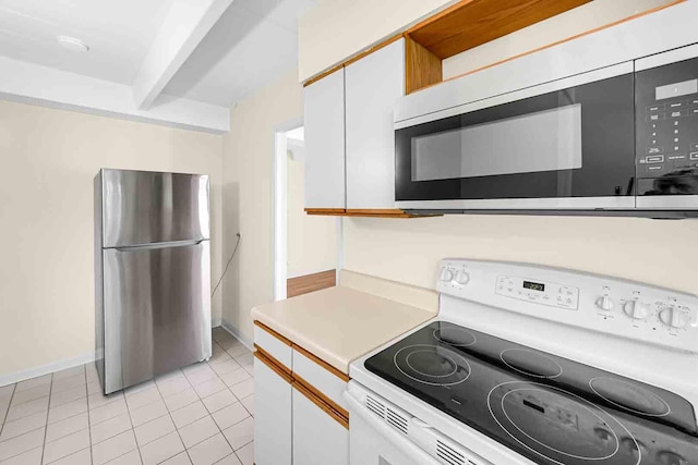 kitchen with white cabinetry, light tile patterned floors, stainless steel appliances, and beam ceiling