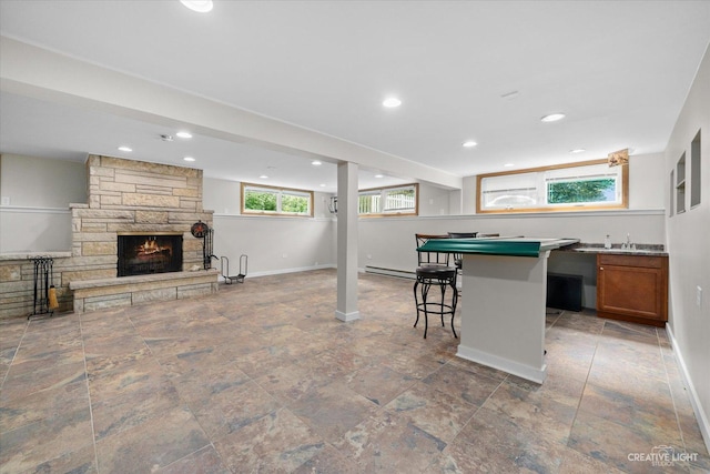 12N988 Engel Rd, Sycamore, IL 60178 - interior space featuring a kitchen bar, a stone fireplace, brown cabinets, a baseboard heating unit, and open floor plan