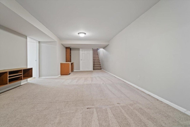 interior space with carpet floors, baseboards, and stairs