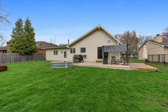 back of house featuring a patio area, a fenced backyard, and a lawn