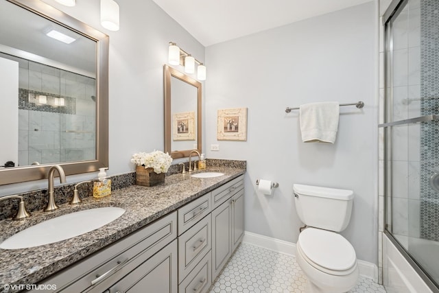bathroom with a sink, tile patterned floors, baseboards, and toilet