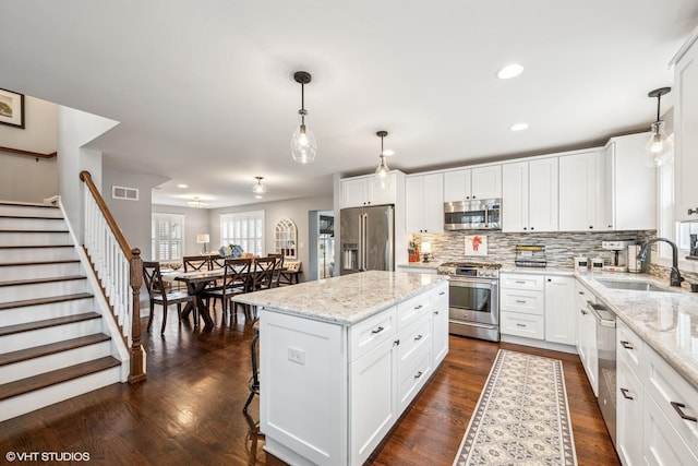 kitchen featuring dark wood-style flooring, a sink, visible vents, and stainless steel appliances