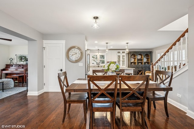 dining space featuring stairs, dark wood-style flooring, and baseboards
