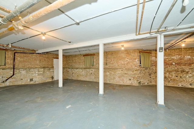 unfinished basement featuring brick wall