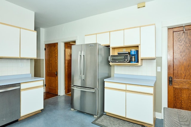 kitchen featuring white cabinetry, light countertops, backsplash, and appliances with stainless steel finishes